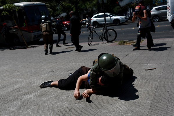 A demonstrator is detained during a protest against Pope Francis' tour of Chile in Santiago.