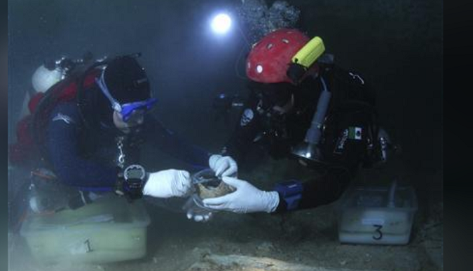 Archaeologists measure the 10,000-year-old skeleton of a boy found at the bottom of an underwater cave near Tulum in 2010.