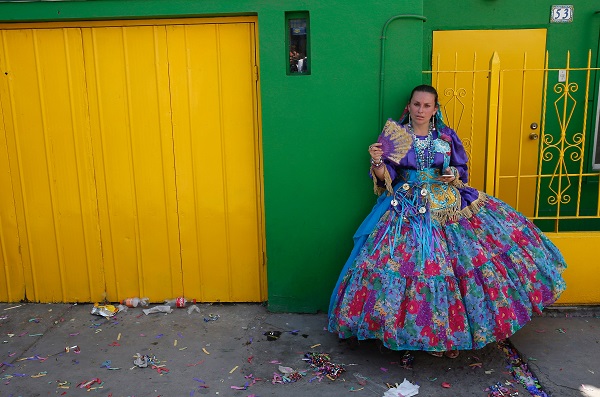 A woman from the Bolivian community in Iquique takes a break after a Diablada performance before the arrival of Pope Francis. The earliest record of the Diablada dates to pre-Hispanic times and the dance of 