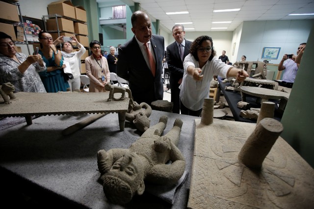 Costa Rica's President Luis Guillermo Solis looks at part of the 196 pre-Columbian pieces returned by the Venezuelan government after the pieces were taken out of the country to Venezuela illegally, at the National Museum in San Jose, Costa Rica, January 17, 2018. Juan Carlos Ulate