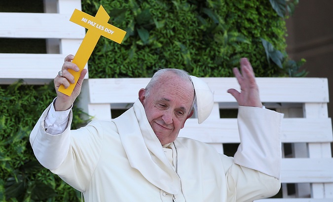 Pope Francis holds a cross during a meeting with youth in Santiago.