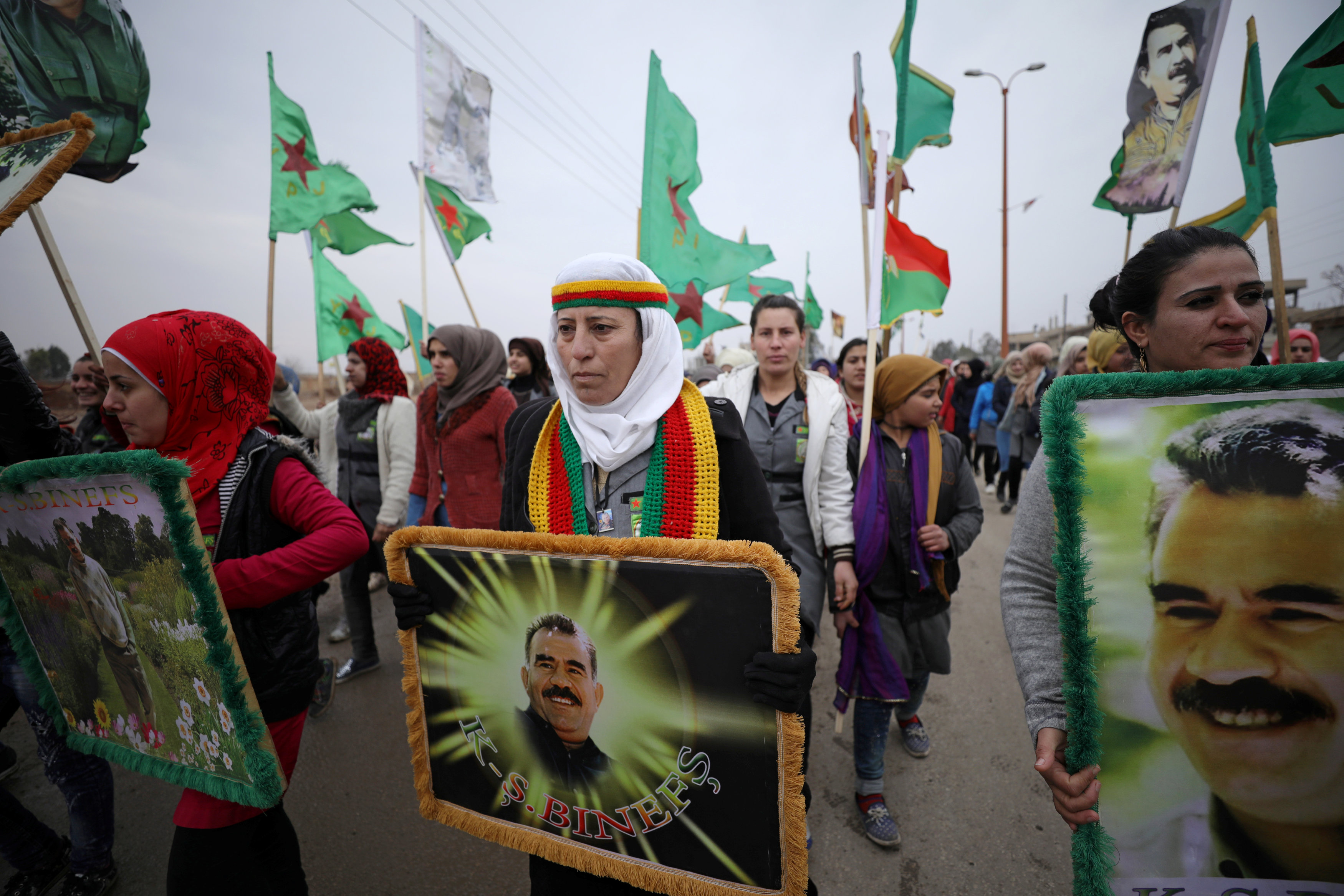A woman holds a picture of Kurdish leader Abdullah Ocalan of PKK during a protest against Turkish attacks on Afrin, in Hasaka province, Syria, Jan. 18, 2018.