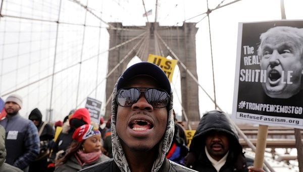 Demonstrators protesting against US President Donald Trump's recent statements about immigration and Haiti march over the Brooklyn Bridge in New York.