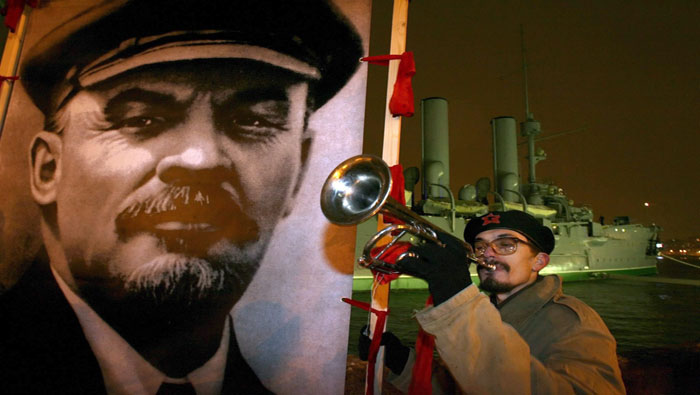 Un comunista toca la trompeta junto a un cartel de Vladimir Lenin, durante una manifestación para conmemorar el aniversario de la Revolución Bolchevique en 2006.