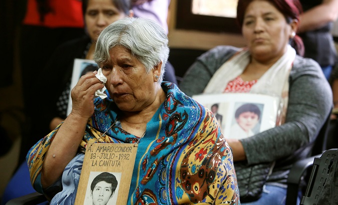 Raida Condor reacts next to Gladys Rubina and Rosa Rojas, relatives of victims under Alberto Fujimori's rule, during a press conference on Feb. 1, 2018.