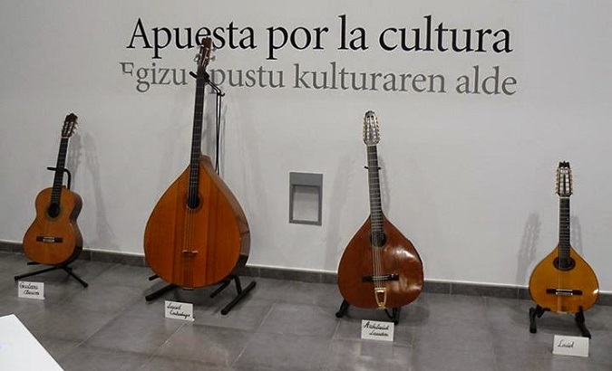 A collection of plectrum instruments used by the group rests against the wall with the words 