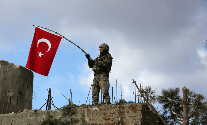 A Turkish soldier waves a flag on Mount Barsaya, northeast of Afrin.