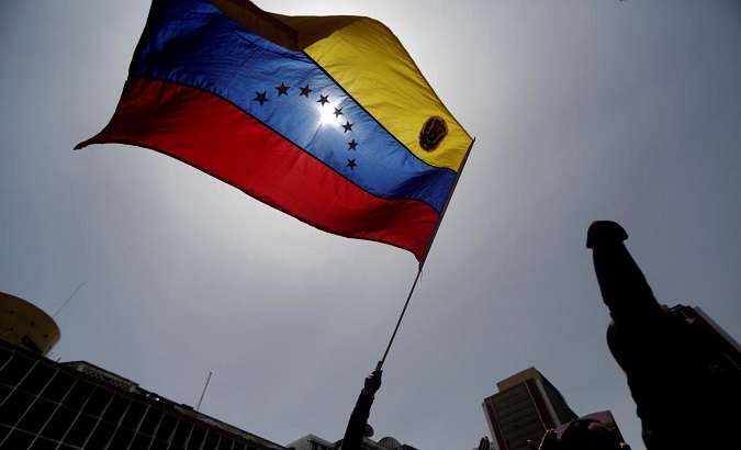 A pro-government protester holds a Venezuelan flag.