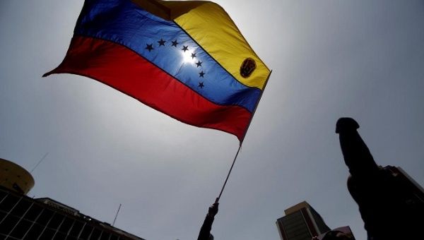 A pro-government protester holds a Venezuelan flag.