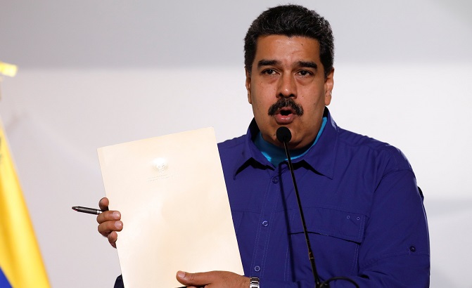 Venezuela's President Nicolas Maduro holds a document as he talks to the media before an event with supporters of Somos Venezuela (We are Venezuela) movement in Caracas, Venezuela February 7, 2018.