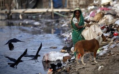 A woman collects garbages from a dump yard near a tannery at Hazaribagh along the polluted Buriganga river in Dhaka.