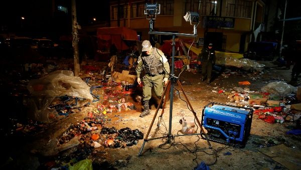 A police office inspects the site of a cooking gas bottle explosion, resulting in deaths, according to local media, during the Carnival parade in Oruro, Bolivia Feb. 10, 2018.