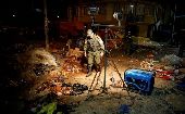 A police office inspects the site of a cooking gas bottle explosion, resulting in deaths, according to local media, during the Carnival parade in Oruro, Bolivia Feb. 10, 2018.