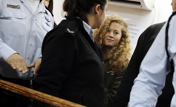 Palestinian teen Ahed Tamimi enters a military courtroom escorted by Israeli police at Ofer Prison, near the West Bank city of Ramallah, Feb. 13, 2018.