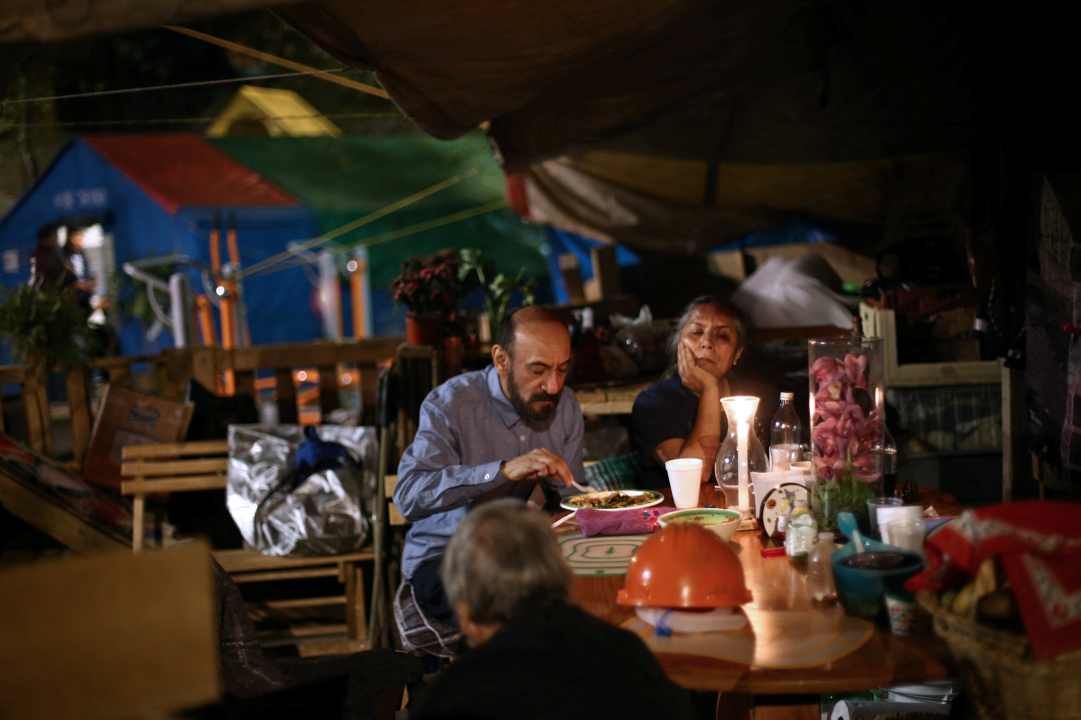 People eat in a makeshift shelter for families affected by an earthquake in the Tlalpan housing project, five months after the September 19 earthquake, in the Educacion neighborhood in Mexico City, Mexico February 16, 2018.
