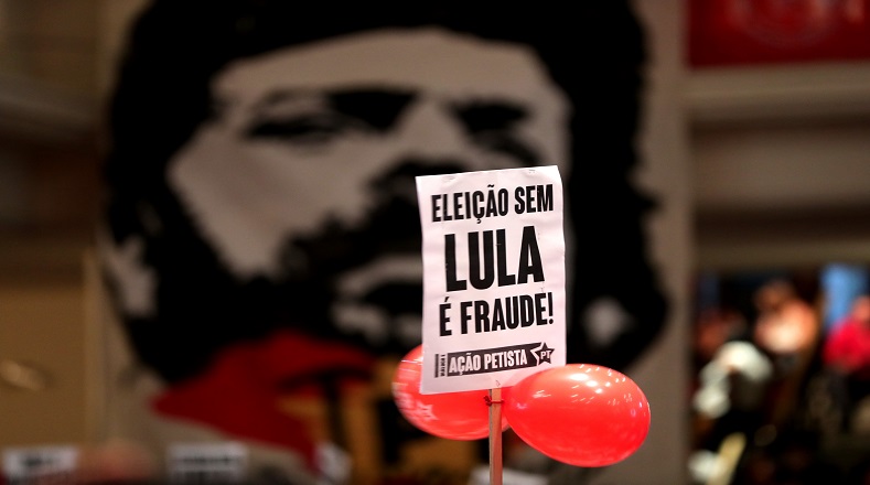Carteles de militantes del PT que dicen: "Elección sin Lula es fraude" y "No a la intervención militar en Río" .