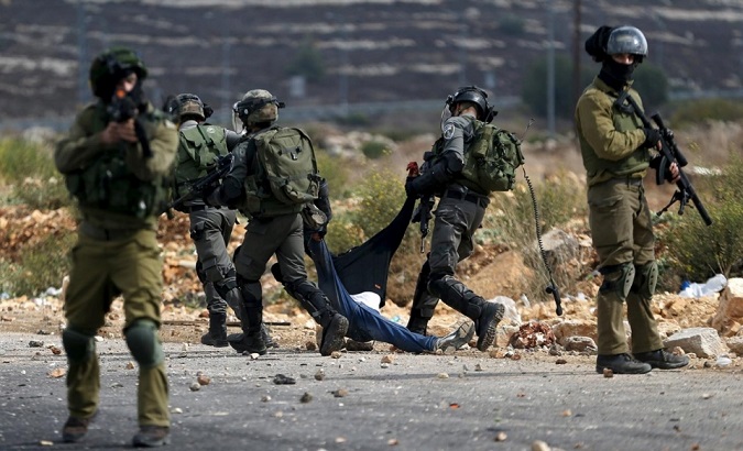 Israeli soldiers detain wounded Palestinian protesters during the clashes near Ramallah.