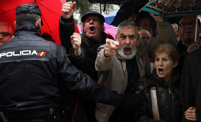 Spanish national police officers prevent pensioners from reaching parliament at the end of the demonstration in Madrid.