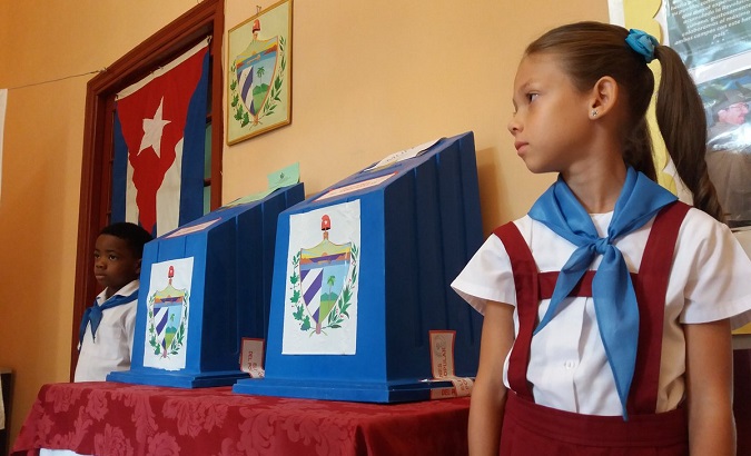 Cuban children stand next to ballot boxes at a school in Havana, Cuba.