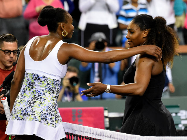 Venus Williams (L) and Serena Williams move to embrace after their Indian Wells third-round fixture.