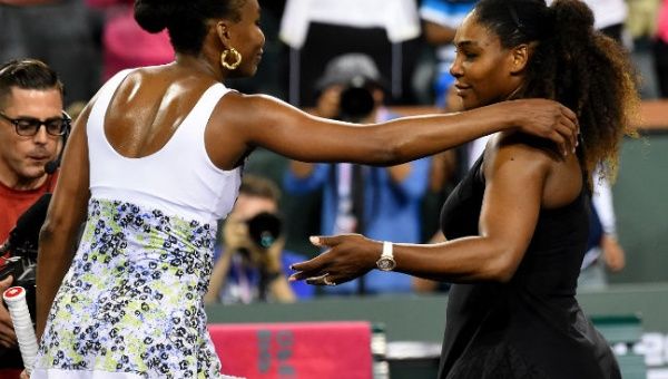 Venus Williams (L) and Serena Williams move to embrace after their Indian Wells third-round fixture.