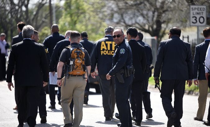 Police and federal agents walk away from a news conference near the scene where a woman was injured in a package bomb explosion in Austin, Texas, United States.