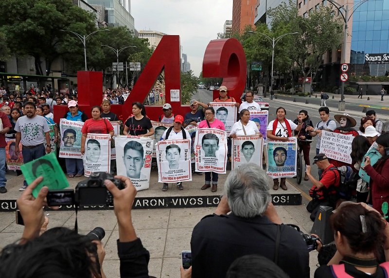 Relatives pose with images of some of the 43 missing Ayotzinapa students in front of the anti-monument of the number 43, during a march in Mexico City.