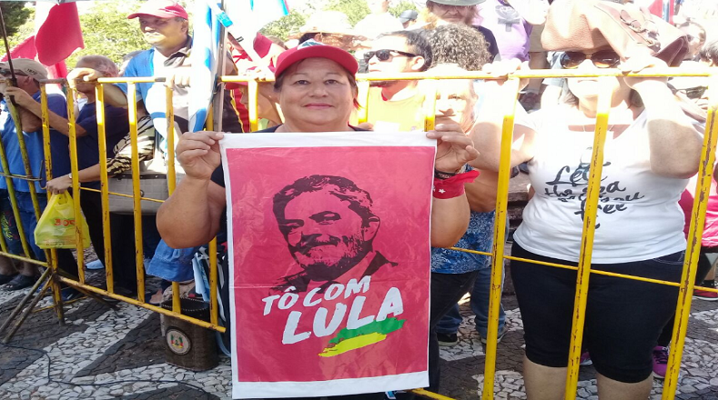 Una mujer sostiene un pendón con la cara de Lula da Silva.