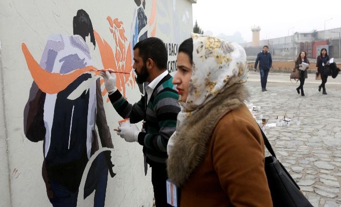 Afghan Artlords paint a message on a wall at the American University of Afghanistan in Kabul.