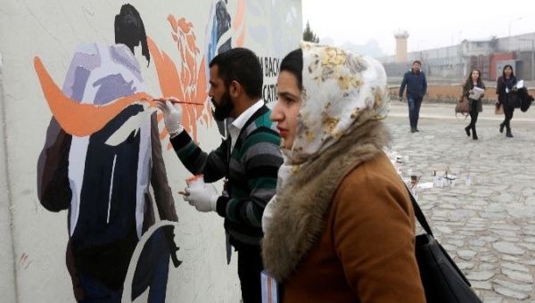 Afghan Artlords paint a message on a wall at the American University of Afghanistan in Kabul.