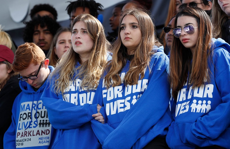 Students listen as Emma Gonzalez, a survivor of the Marjory Stoneman Douglas High School mass shooting in Florida, addresses crowds at the 'March for Our Lives' event.