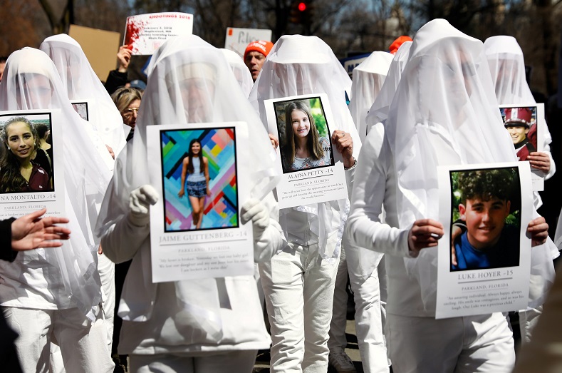 Protesters hold photos of school shooting victims during a demonstration demanding stricter gun controls in New York City.