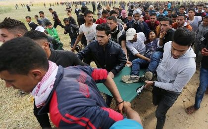 A wounded Palestinian is evacuated during clashes with Israeli troops, during a tent city protest along the Israel border with Gaza, demanding the right to return to their homeland, the southern Gaza Strip March 30, 2018. 