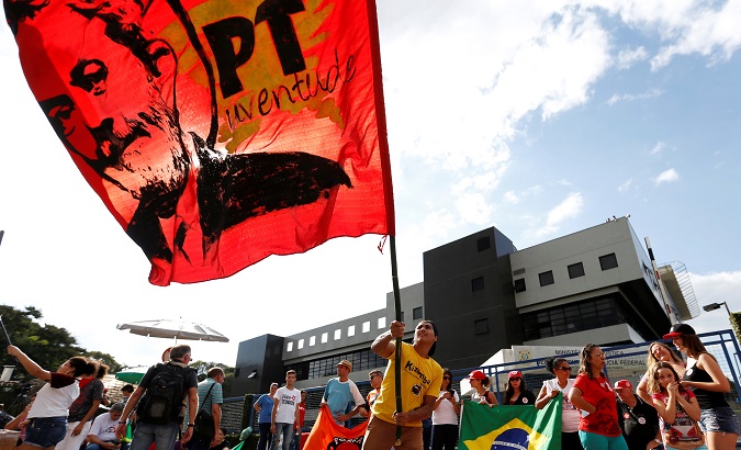 A supporter of former Brazilian President Luiz Inacio Lula da Silva waves a flag with Lula's face during a protest against his sentence.