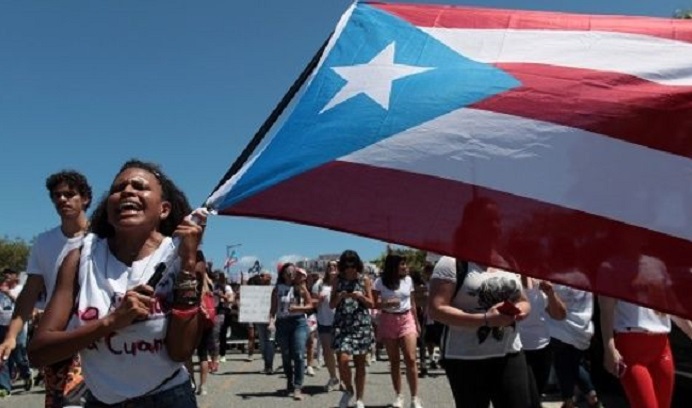 Students of the University of Puerto Rico wave the flag of their Island during a protest.