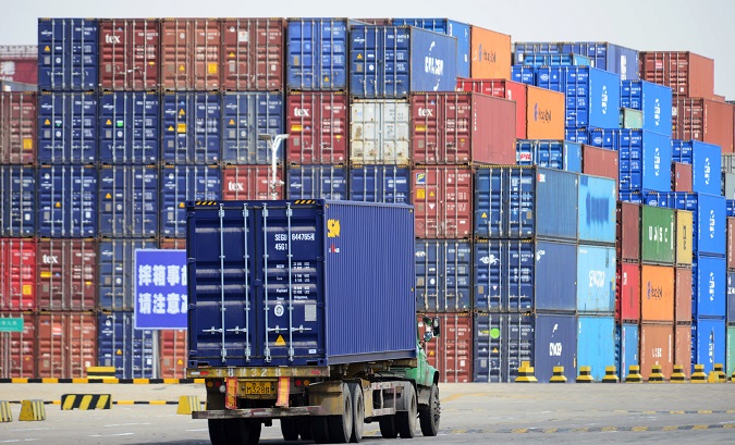 A truck transporting a shipping container is seen at a cargo terminal at a port in Qingdao, Shandong province, China April 6, 2018