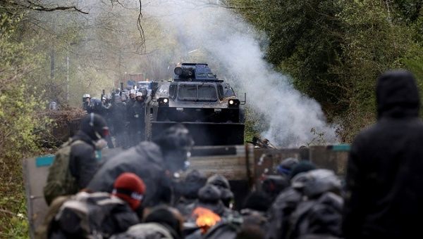 Protesters gather as French gendarmes advance with an armoured vehicle during clashes during an evacuation operation in the zoned ZAD.