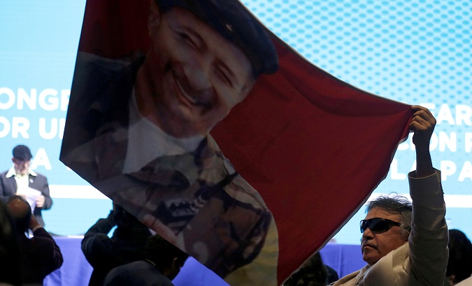 Colombia's FARC member Jesus Santrich waves a flag of former leader Victor Julio Suarez, known as Mono Jojoy.