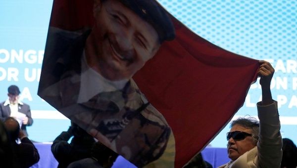 Colombia's FARC member Jesus Santrich waves a flag of former leader Victor Julio Suarez, known as Mono Jojoy.