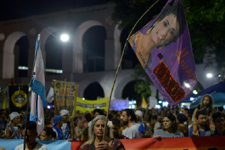 Demonstrators take part in a protest against the shooting of Rio de Janeiro city councillor Marielle Franco one month after her death.