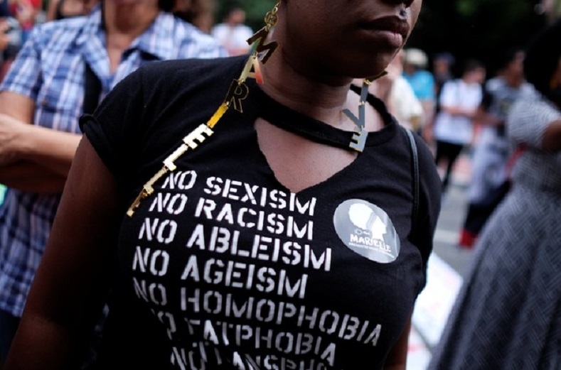 A demonstrator wearing an earring which reads: 