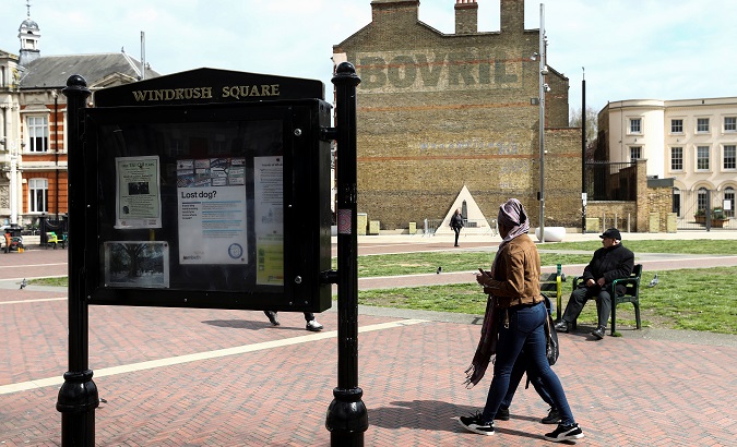 People walk past a sign on Windrush Square in the Brixton district of London, Britain April 16, 2018.