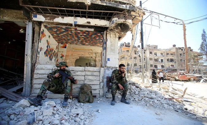 Members of Syrian police sit at a damaged building at the city of Douma, Damascus, Syria April 16, 2018.