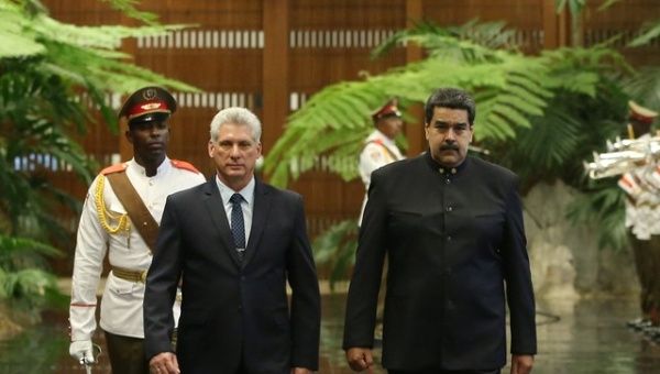 Cuban President Miguel Diaz-Canel (L) and Venezuela's President Nicolas Maduro review an honour guard during a ceremony at the Revolution Palace in Havana, Cuba April 21, 2018.