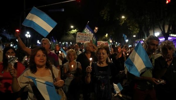 Demonstrators hold candles and wave Argentine national flags during a protest against utility rate hikes in Buenos Aires, Argentina, April 19, 2018. 