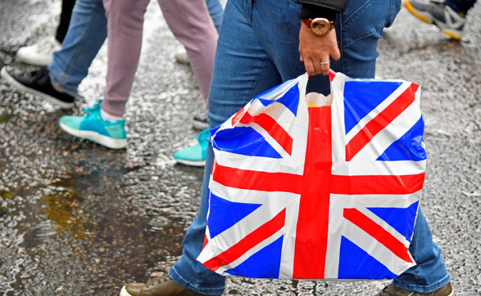 A pedestrian carries a British union flag design plastic bag in Leicester Square in London, Britain, March 29, 2018.