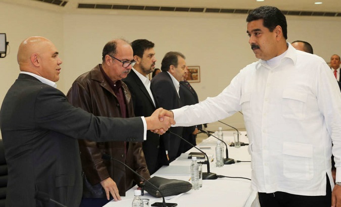 President Nicolas Maduro (R) shakes hands with Jesus Torrealba (L), former secretary of Venezuela's coalition of opposition parties in Caracas in 2016.