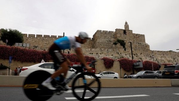 A rider practises opposite to the David Tower of Jerusalem's Old City before the beginning of Stage 1.