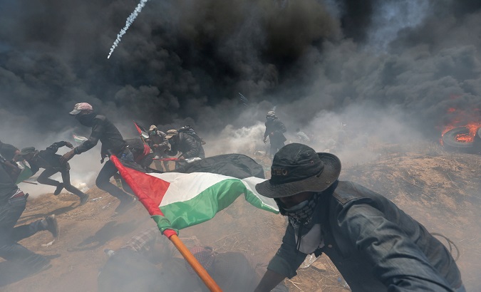 Palestinian demonstrators run for cover from Israeli fire during a protest against U.S. embassy move to Jerusalem at the Israel-Gaza border in the southern Gaza Strip.