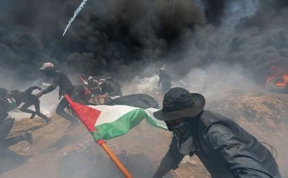 Palestinian demonstrators run for cover from Israeli fire during a protest against U.S. embassy move to Jerusalem at the Israel-Gaza border.